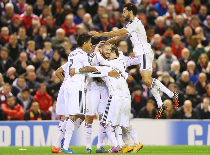 Karim Benzema of Real Madrid celebrates with teammates after scoring against Liverpool during their UEFA Champions League Group B match in Liverpool on Wednesday