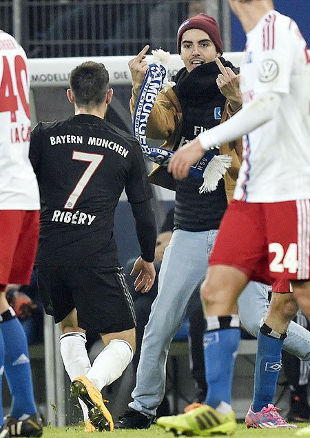 A pitch invader reacts in front of FC Bayern Munich's Franck Ribery (7) during their German soccer cup (DFB Pokal) match against Hamburger S