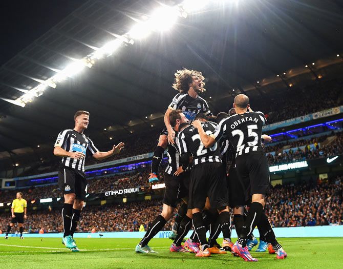 oussa Sissoko of Newcastle United is mobbed by teammates after scoring their second goal against Manchester City during the League Cup fourth round match at Etihad Stadium in Manchester on Wednesday