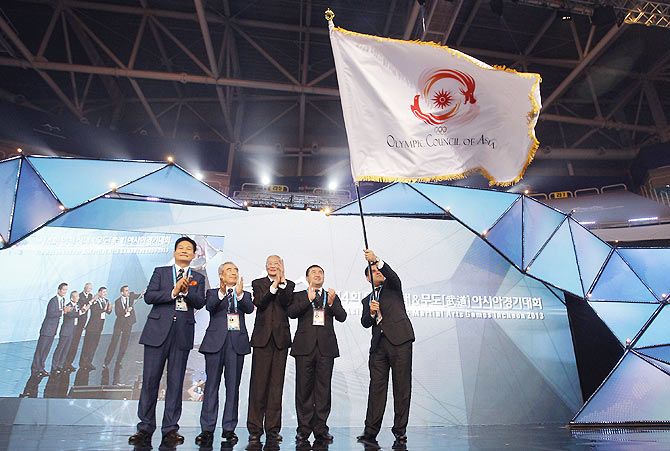 Rejepgeldy Nurmammedow (R), Head of Government of Ashghabat city, Turkmenistan, the next host city of Asian Indoor & Martial Arts Games waves OCA flag