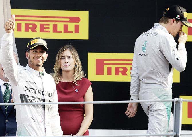 Winner Mercedes Formula One driver Lewis Hamilton, left, of Britain celebrates on the podium besides second-placed team mate Nico Rosberg