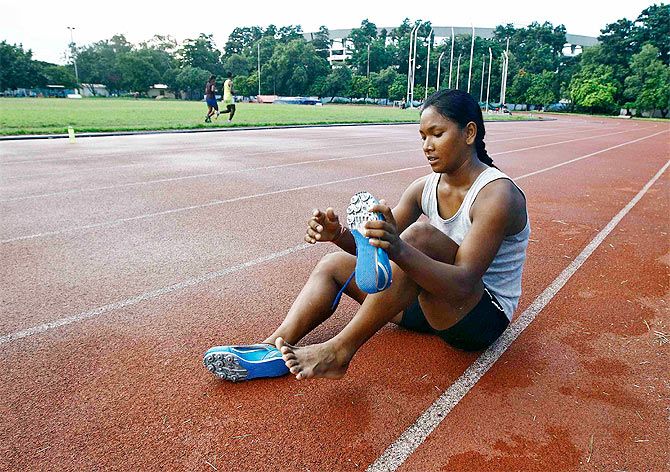Heptathlete Swapna Barman removes her track shoes after a practice session at Salt Lake stadium in Kolkata