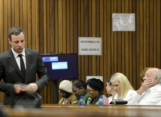 Oscar Pistorius walks past Reeva Steenkamp's parents in the Pretoria High Court