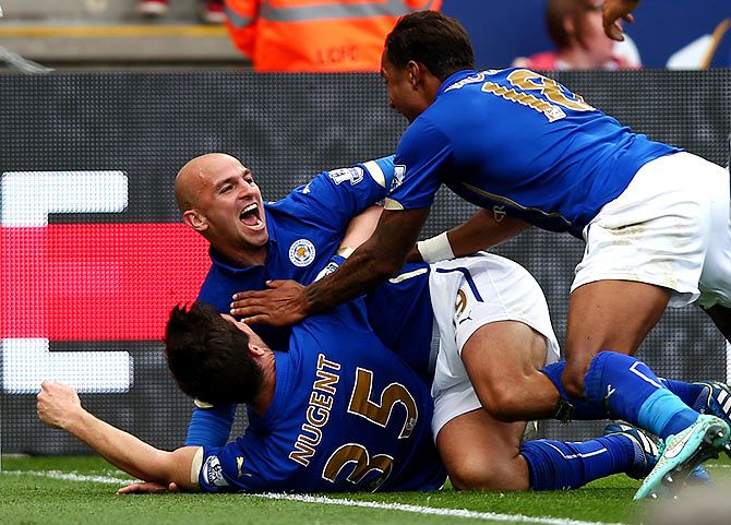 Esteban Cambiasso of Leicester City celebrates with teammates David Nugent and Liam Moore after scoring his team's third goal during the Barclays Premier League match against Manchester United at The King Power Stadium in Leicester on Sunday