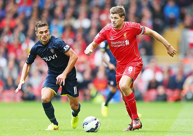 Steven Gerrard of Liverpool is closed down by Dusan Tadic of Southampton during the Barclays Premier League match