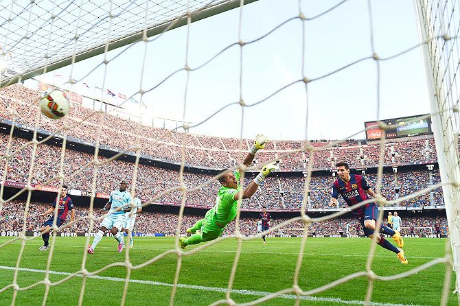 Lionel Messi of FC Barcelona scores his team's fourth goal during the La Liga match between FC Barcelona and Granada CF at Camp Nou on Saturday