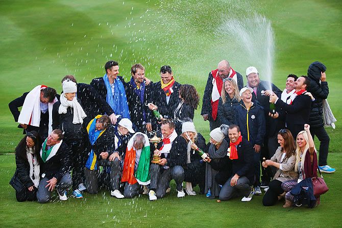 Europe team captain Paul McGinley poses with the Ryder Cup trophy, his team and their partners and wives after the Singles Matches of the 2014 Ryder Cup on the PGA Centenary course at the Gleneagles Hotel in Auchterarder, Scotland, on Sunday