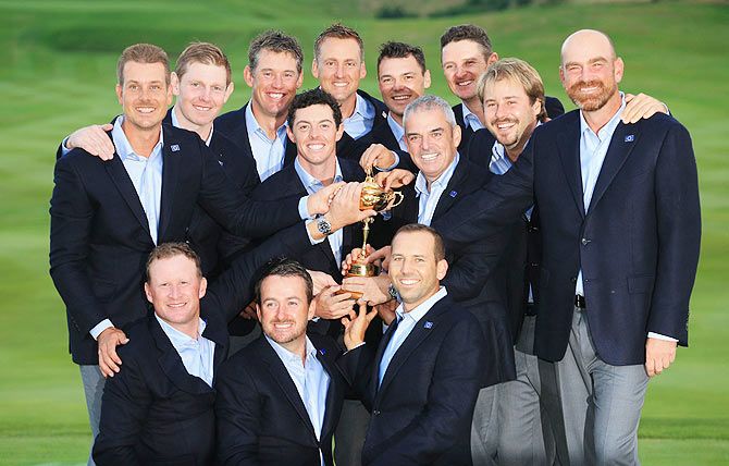 Europe team captain Paul McGinley poses with the Ryder Cup trophy and his team after the Singles Matches