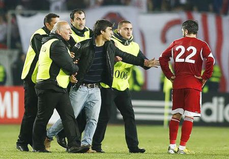 Georgia's George Navalovsky (right) watches security guards detaining a supporter, who ran onto the pitch, during their Euro 2016 qualifier against Germany in Tbilisi on March 29