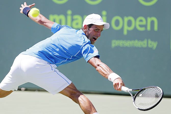 Novak Djokovic reaches for a backhand against Andy Murray