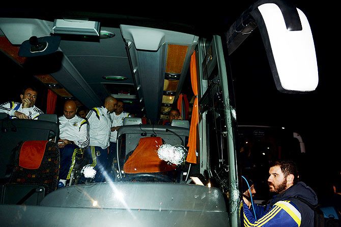 Fenerbahce officials wait in the damaged team bus which was shot at while it was being driven through to Trabzon Airport in the Black Sea coastal province of Trabzon on Saturday