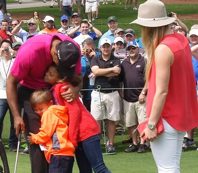 Tiger Woods of the US gets a hug from his daughter Sam and son Charlie