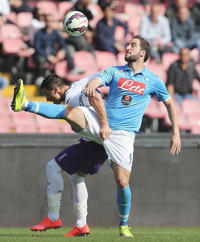 Napoli's Gonzalo Higuain (right) competes for the ball with Fiorentina Manuel Pasqual during their match at Stadio San Paolo in Naples on Sunday