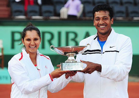 Sania Mirza and Mahesh Bhupathi pose with the winners trophy after their 2012 French Open mixed doubles final victory at Roland Garros
