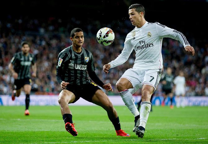 Real Madrid's Cristiano Ronaldo (right) competes for the ball with Malaga's Roberto Rosales during their La Liga match at Estadio Santiago Bernabeu in Madrid on Saturday