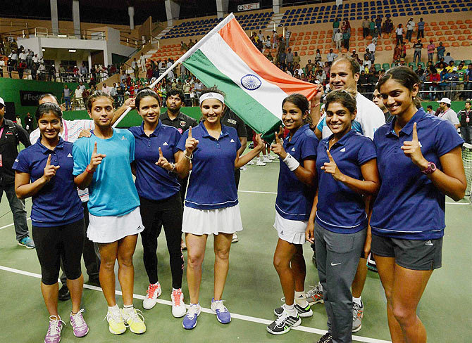 Indian tennis player Sania Mirza (centre) waves the Indian flag with team members after winning the Fed Cup Asia-Oceana Group II doubles match against Philippines' Katharina Lehnert and Anna Clarice Patrimonio in Hyderabad on Saturday