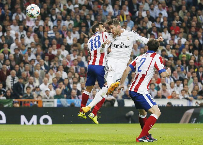 Real Madrid's Sergio Ramos is challenged by Atletico players