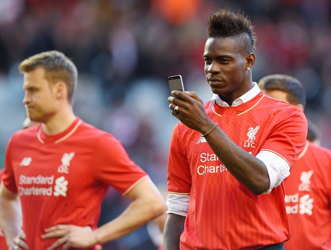 Mario Balotelli of Liverpool takes pictures of the fans on his phone