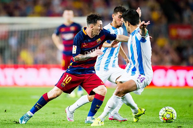 FC Barcelona's Lionel Messi tries to break the defensive barrier made by Malaga's Jose Luis Garcia 'Recio'