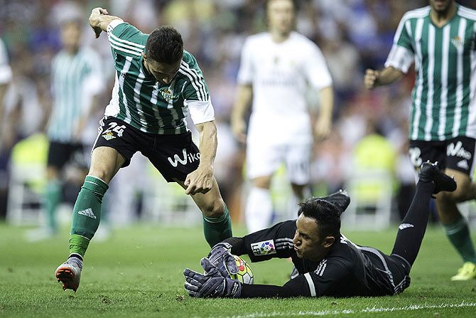 Real Madrid's goalkeeper Keylor Navas (right) stops the attack of Real Betis' Ruben Castro (left)