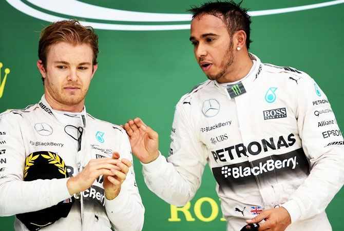 Lewis Hamilton of Great Britain and Mercedes GP on the podium next to Nico Rosberg