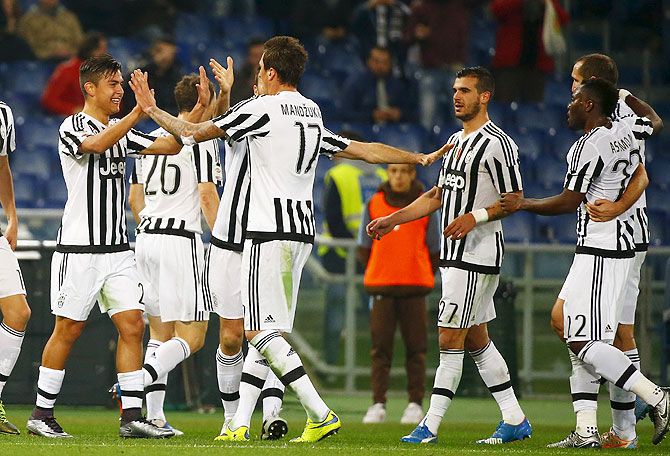 Juventus' Paulo Dybala (left) celebrates with teammates after scoring the second goal against Lazio at Olympic Stadium, in Rome, on Friday