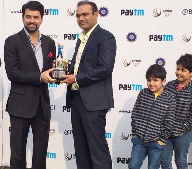 Former India opener Virender Sehwag is felicitated by BCCI secretary Anurag Thakur (left), as the former's sons, Aryavir and Vedant look on during the ceremony at the Feroz Shah Kotla in New Delhi on December 3
