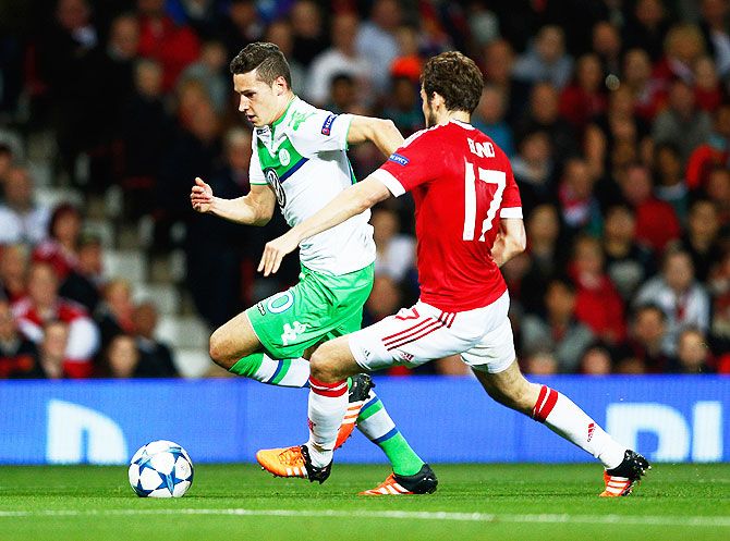 VfL Wolfsburg's Julian Draxler is chased by Manchester United's Daley Blind as they vie for possession