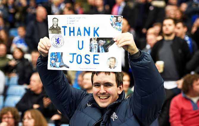 A Chelsea fan poses with a banner for Jose Mourinho before the game on Saturday