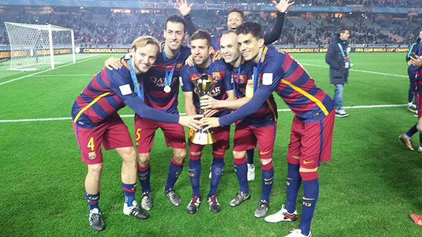 Reigning champions FC Barcelona players celebrate with the Club World Cup trophy after defeating Argentine club River Plate to win the title on December 20, 2015
