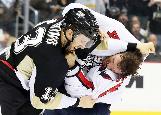 Washington Capitals defenseman Taylor Chorney (4) and Pittsburgh Penguins center Nick Bonino (13) fight during the second period of their ice hockey match at the CONSOL Energy Center in Pittsburgh on Monday