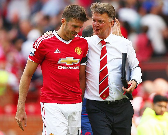 Manchester United's Michael Carrick walks with manager Louis van Gaal