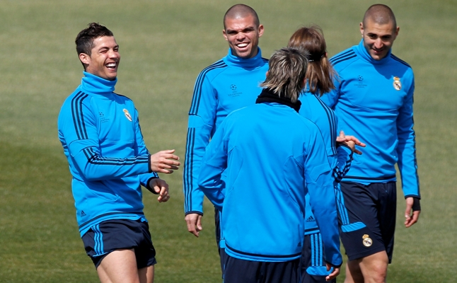 Cristiano Ronaldo (L) smiles beside Pepe (2nd L) and Karim Benzema (R) of Real Madrid CF during a training session 