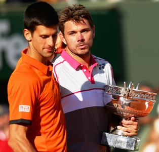 Runner up Novak Djokovic of Serbia leaves the podium as Stanislas Wawrinka of Switzerland poses with the French Open trophy 