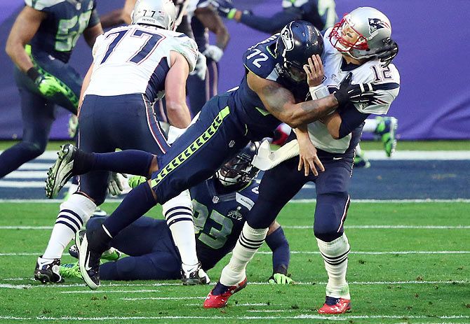 Michael Bennett #72 of the Seattle Seahawks hits Tom Brady #12 of the New England Patriots in the first half during Super Bowl XLIX