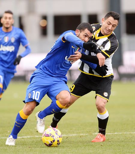 Ivan Piris (right) of Udinese Calcio challenges Carlos Tevez of Juventus FC during their Serie A match at Stadio Friuli in Udine on Sunday