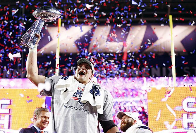 New England Patriots tight end Rob Gronkowski hoists the Vince Lombardi Trophy after defeating the Seattle Seahawks in Super Bowl XLIX at University of Phoenix Stadium on Sunday