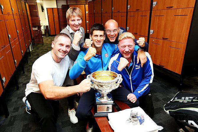 Novak Djokovic, his coach Boris Becker, his agents Edoardo Artaldi Elena Cappellaro pose with the Norman Brookes Challenge Cup after Djokovic won the Australian Open men's single final on Sunday.