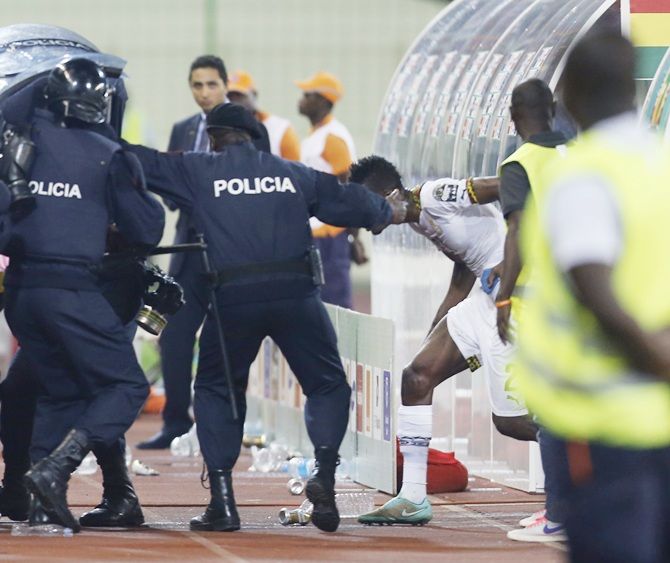 Riot police shield Ghana's players from stones and water bottles thrown by   Equitorial Guinea fans during their semi-final match of African Cup of Nations in Malabo