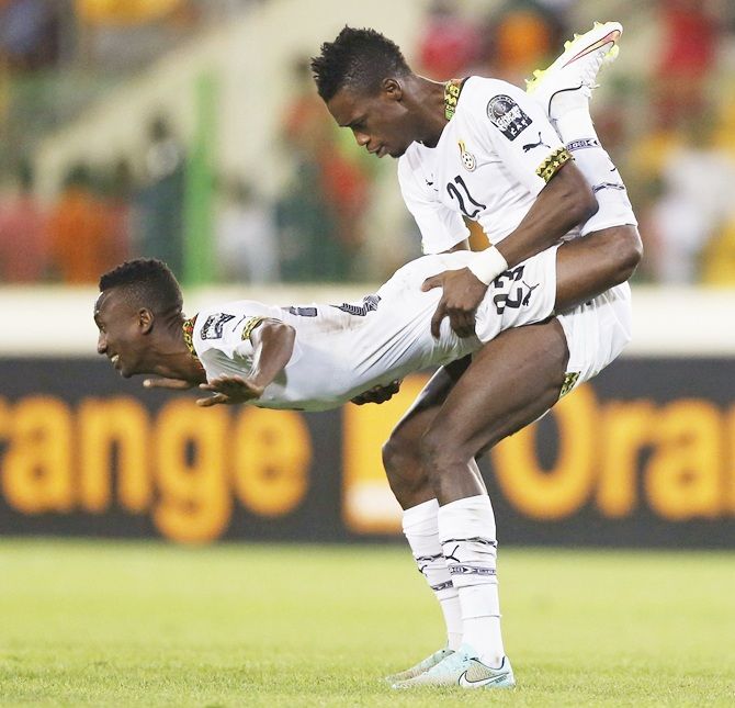 Ghana's John Boye carries his team mate Harrison Afful as they celebrate after their team won their   African Nations Cup semi-final