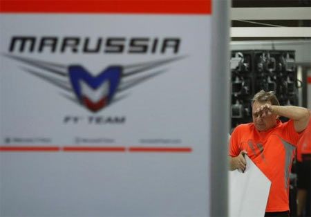 A pit crew of Marussia cleans up the pit after the Japanese F1 Grand Prix at the Suzuka Circuit