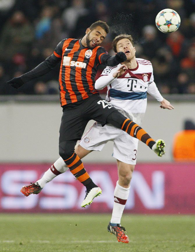 Shakhtar Donetsk's Alex Teixeira (left) challenges Bayern Munich's Xabi Alonso as they vie for an aeriel ball during their Champions League Round of 16 first leg match in Lviv, Ukraine on Tuesday