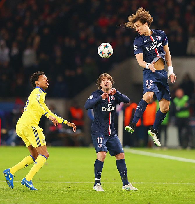 David Luiz of Paris Saint-Germain jumps for a header as teammate Maxwell and Chelsea's Loic Remy look on