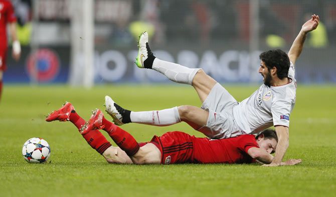 Bayer Leverkusen's Lars Bender goes on the ground after colliding with Atletico Madrid's Raul Garcia (top)