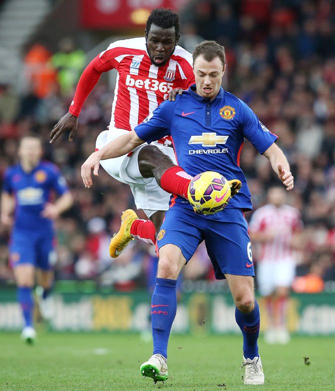 Jonny Evans of Manchester United is challenged by Mame Diouf of Stoke City 