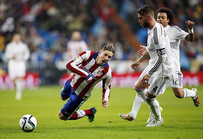 Atletico Madrid's Fernando Torres (left) is fouled by Real Madrid's Sergio Ramos