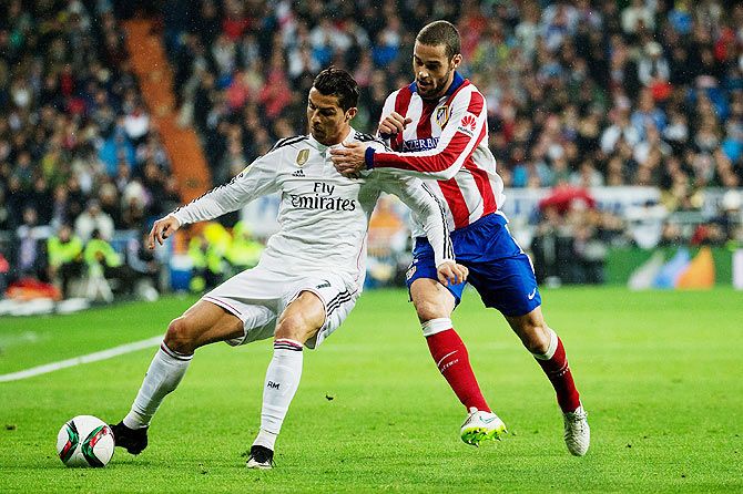 Cristiano Ronaldo (left) of Real Madrid is and with Mario Suarez (left) of Atletico de Madrid vie for possession