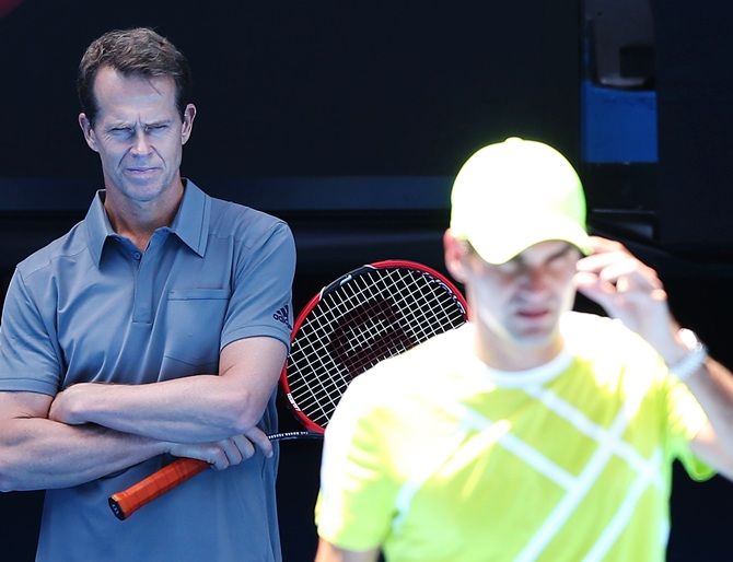 Roger Federer of Switzerland is watched by coach Stefan Edberg during a practice session