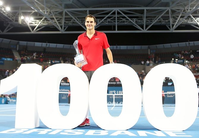 Roger Federer holds the Roy Emerson trophy after registering his 1,000th ATP career victory