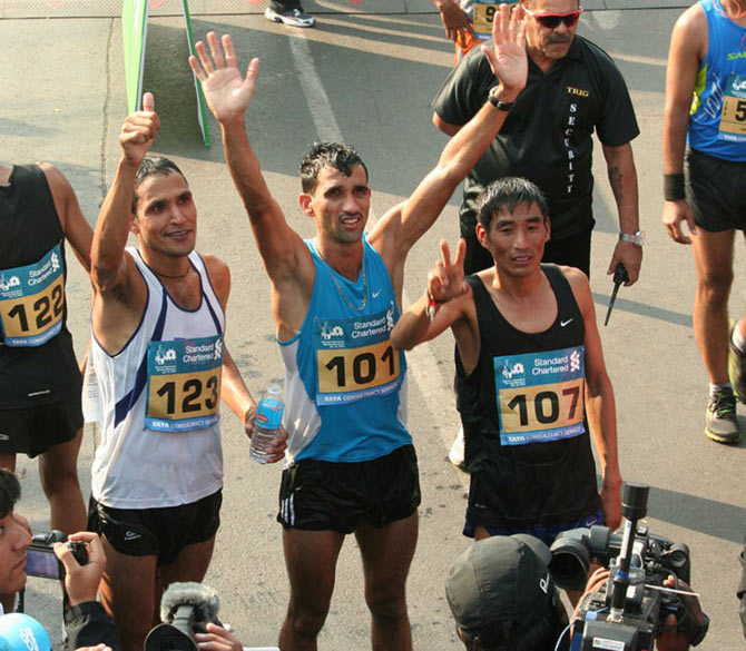 Indian full marathon winners Karan Singh, Arjun Pradhan and Bahadur Singh Dhoni celebrate at the finish line